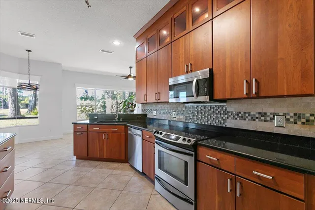 a kitchen with stainless steel appliances granite countertop a stove a sink and a microwave