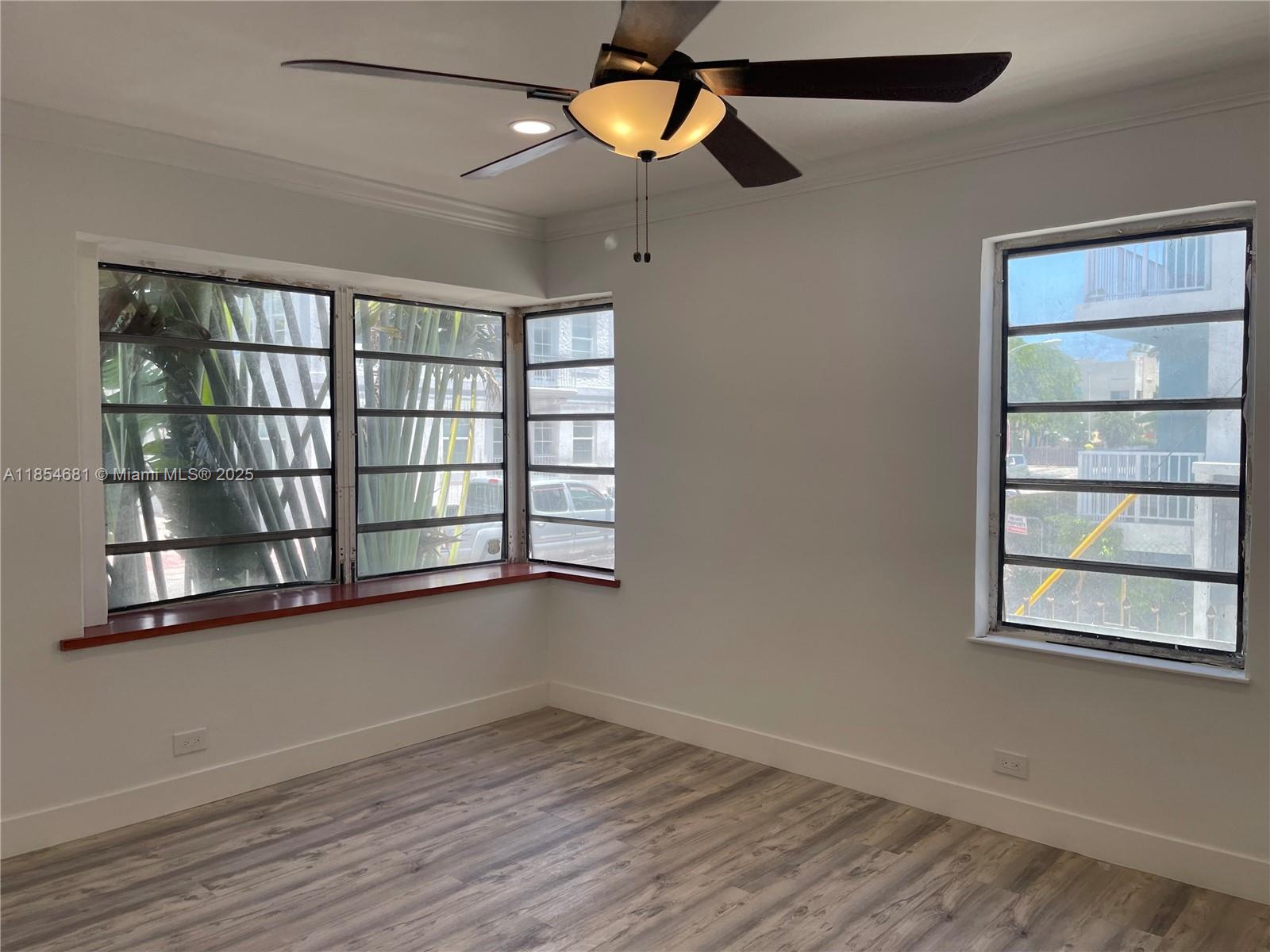 730 12th Street, Unit 10 Miami Beach, FL 33139 - Photo 5 of 12 wooden floor in an empty room with a window