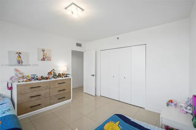 a room with a baby crib and dresser