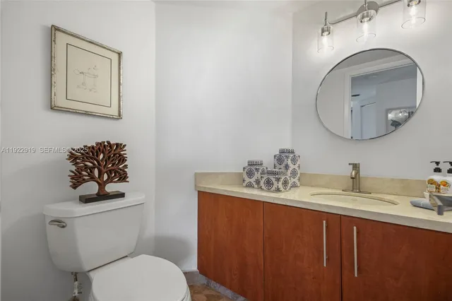 a bathroom with a toilet a sink and mirror