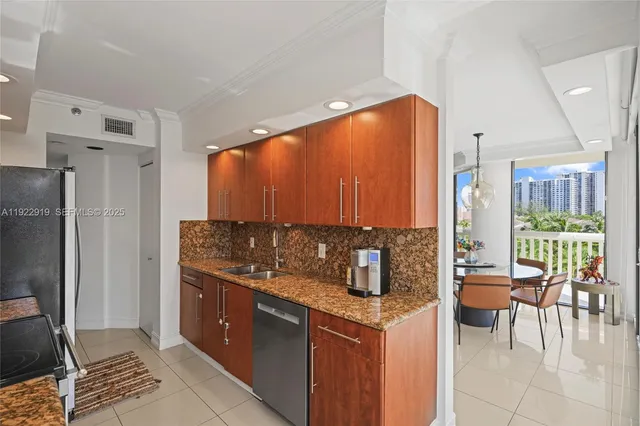 a kitchen with stainless steel appliances kitchen island granite countertop a refrigerator and a stove