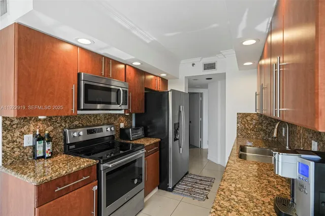a kitchen with stainless steel appliances granite countertop a stove refrigerator and microwave