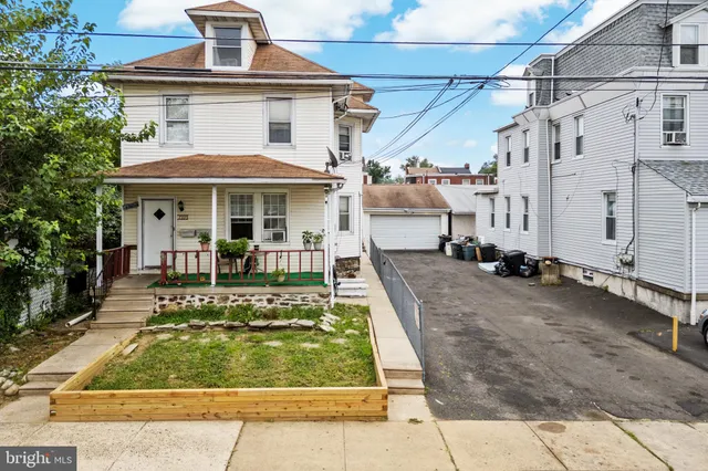 a view of a white building with swimming pool in front of it