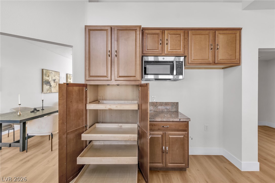 370 Rushing Creek Court Henderson, NV 89014 - Photo 22 of 32 A spacious pantry cabinet features pull-out wooden drawers adjacent to the kitchen prep area.