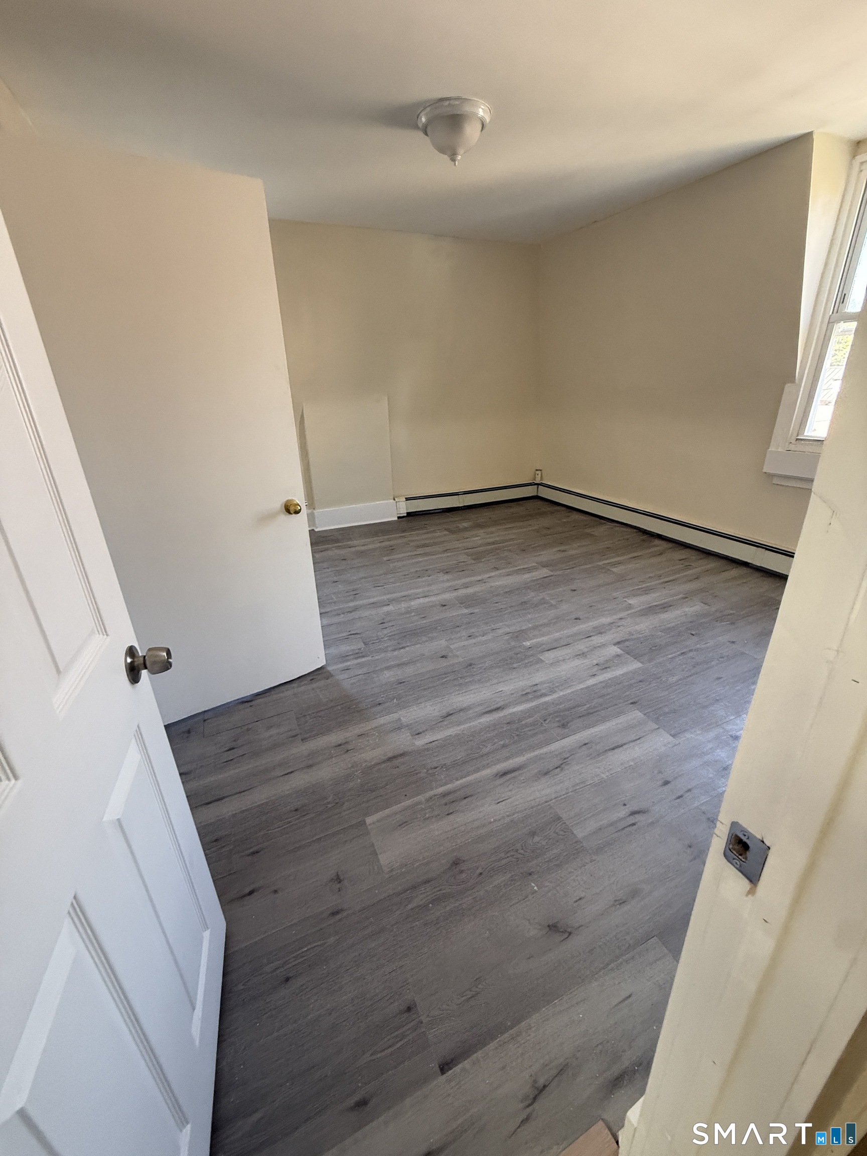 35 Cliff Street Norwich, CT 06360 - Photo 12 of 21 an empty room with wooden floor and white walls