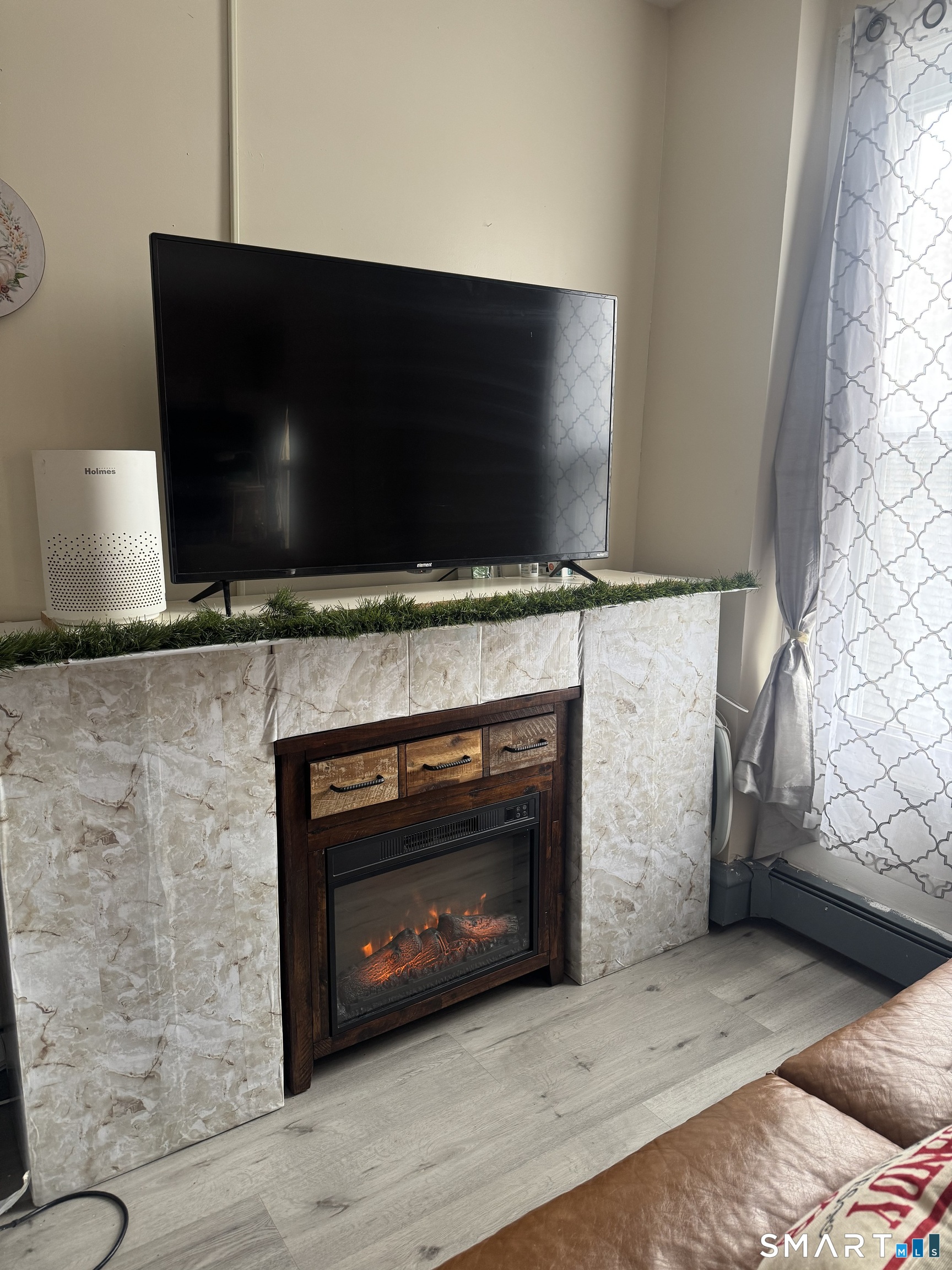 35 Cliff Street Norwich, CT 06360 - Photo 4 of 21 a living room with a fireplace and a flat screen tv