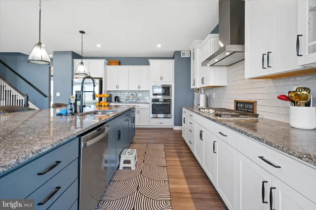 a large kitchen with stainless steel appliances granite countertop a sink counter space and cabinets