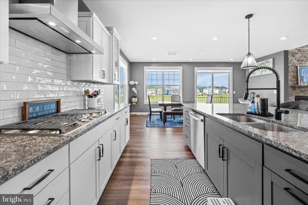 a large kitchen with stainless steel appliances granite countertop a stove a sink dishwasher and a wooden cabinets