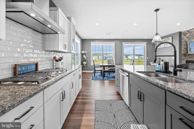 a large kitchen with stainless steel appliances granite countertop a stove a sink dishwasher and a wooden cabinets