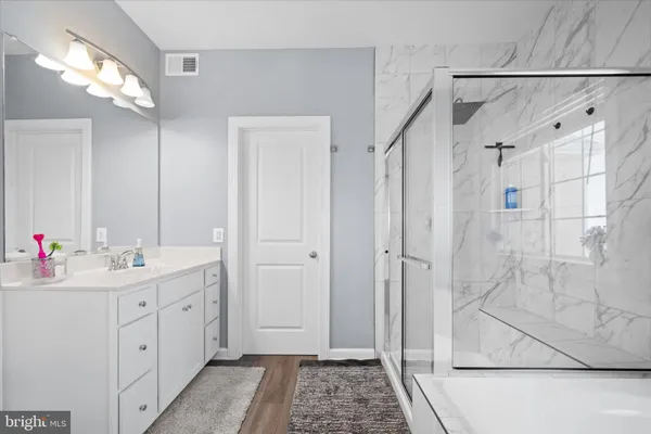 a spacious bathroom with a double vanity sink mirror and shower