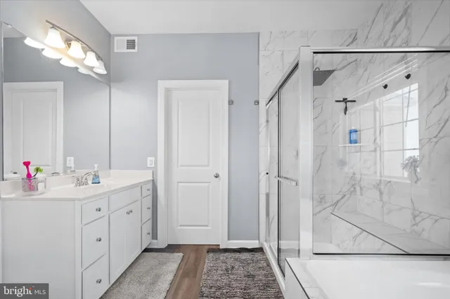a spacious bathroom with a double vanity sink mirror and shower