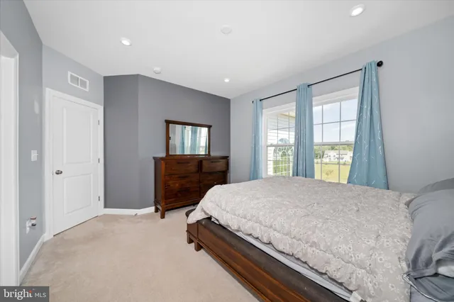 a bedroom with a bed dresser and a window