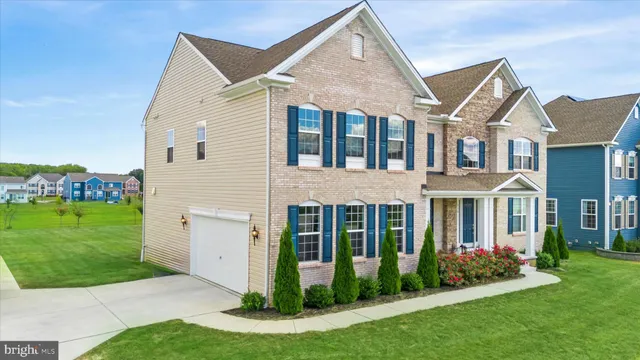 a view of a white house next to a yard with big trees