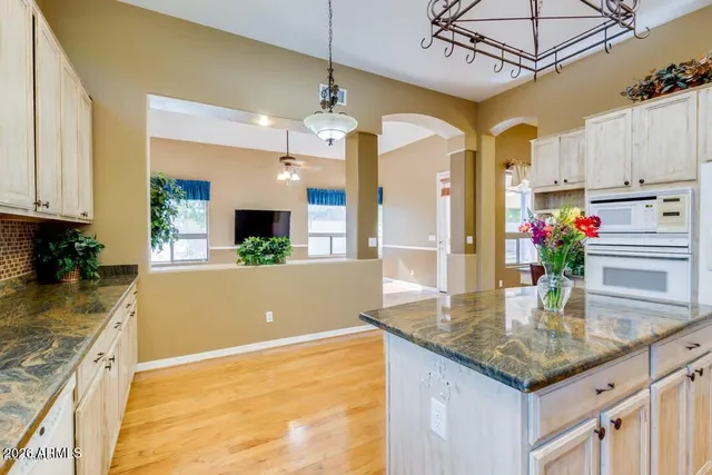 a kitchen with stainless steel appliances granite countertop a sink a stove and a wooden floors