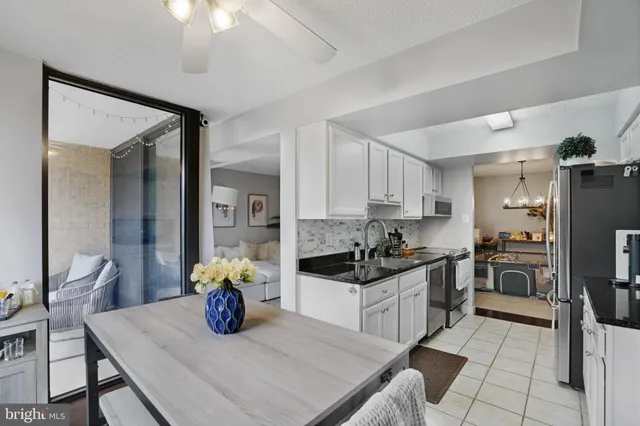 a kitchen with granite countertop a sink cabinets and stainless steel appliances