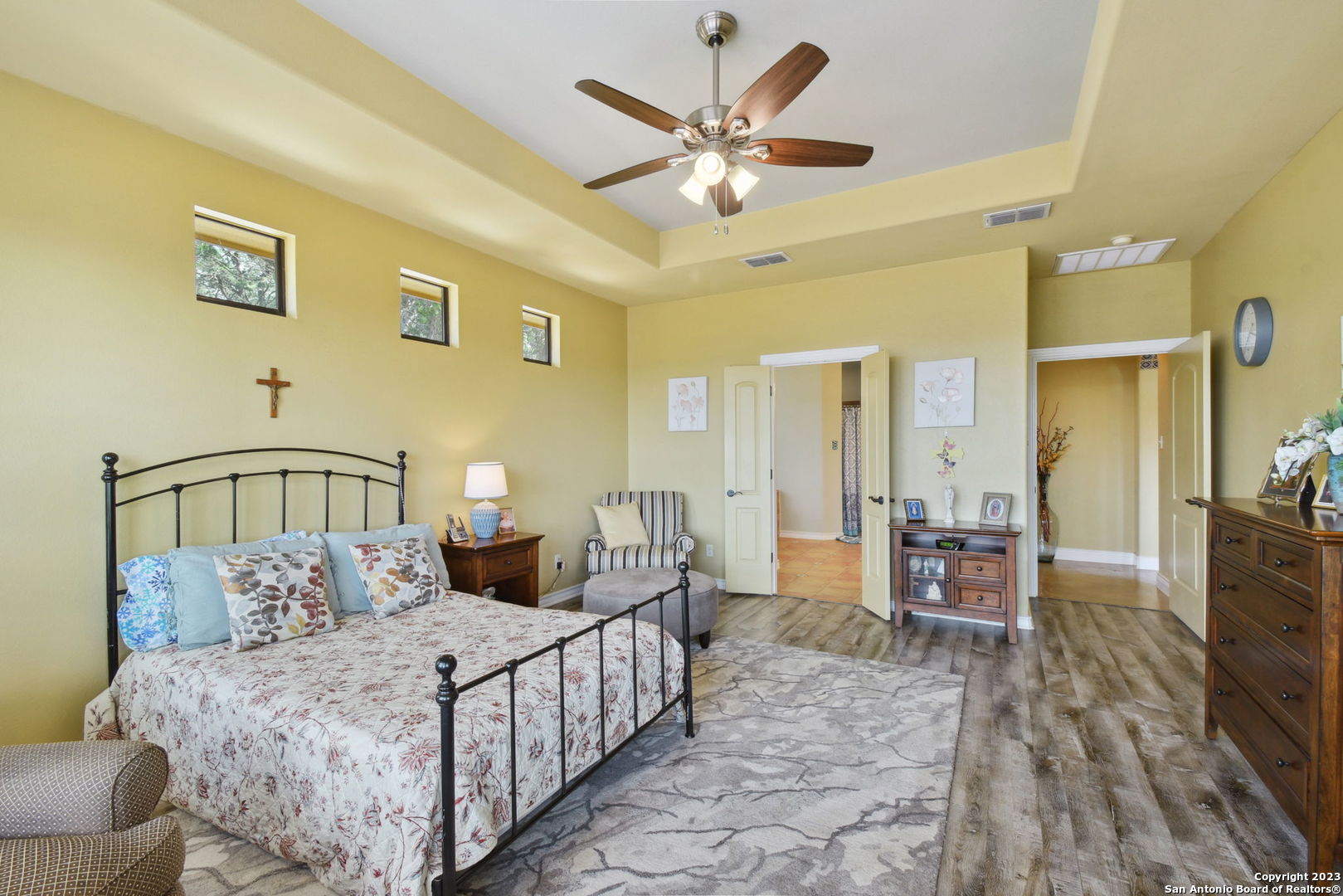 6527 Preakness Pass Bulverde, TX 78163 - Photo 17 of 22 a bedroom with a large bed a chandelier and a couch