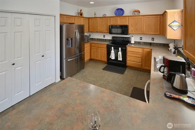 a kitchen with stainless steel appliances kitchen island granite countertop a refrigerator and a stove top oven