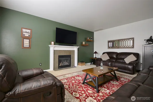 a living room with furniture a flat screen tv and a fireplace