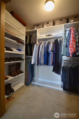 a view of walk in closet with clothes and shoes
