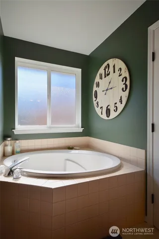 a bathroom with a bathtub and a picture on the wall