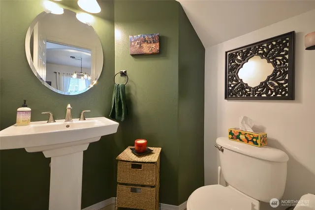 a bathroom with a toilet a sink and a mirror