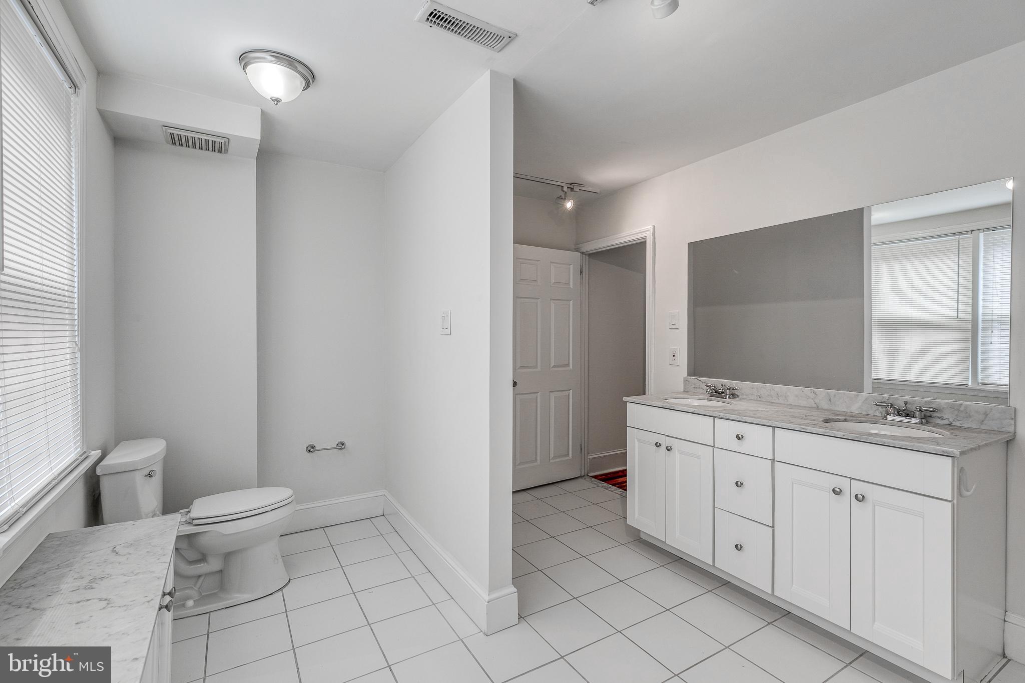 1714 Rittenhouse Square Philadelphia, PA 19103 - Photo 12 of 21 a spacious bathroom with a granite countertop sink a toilet a mirror and a window