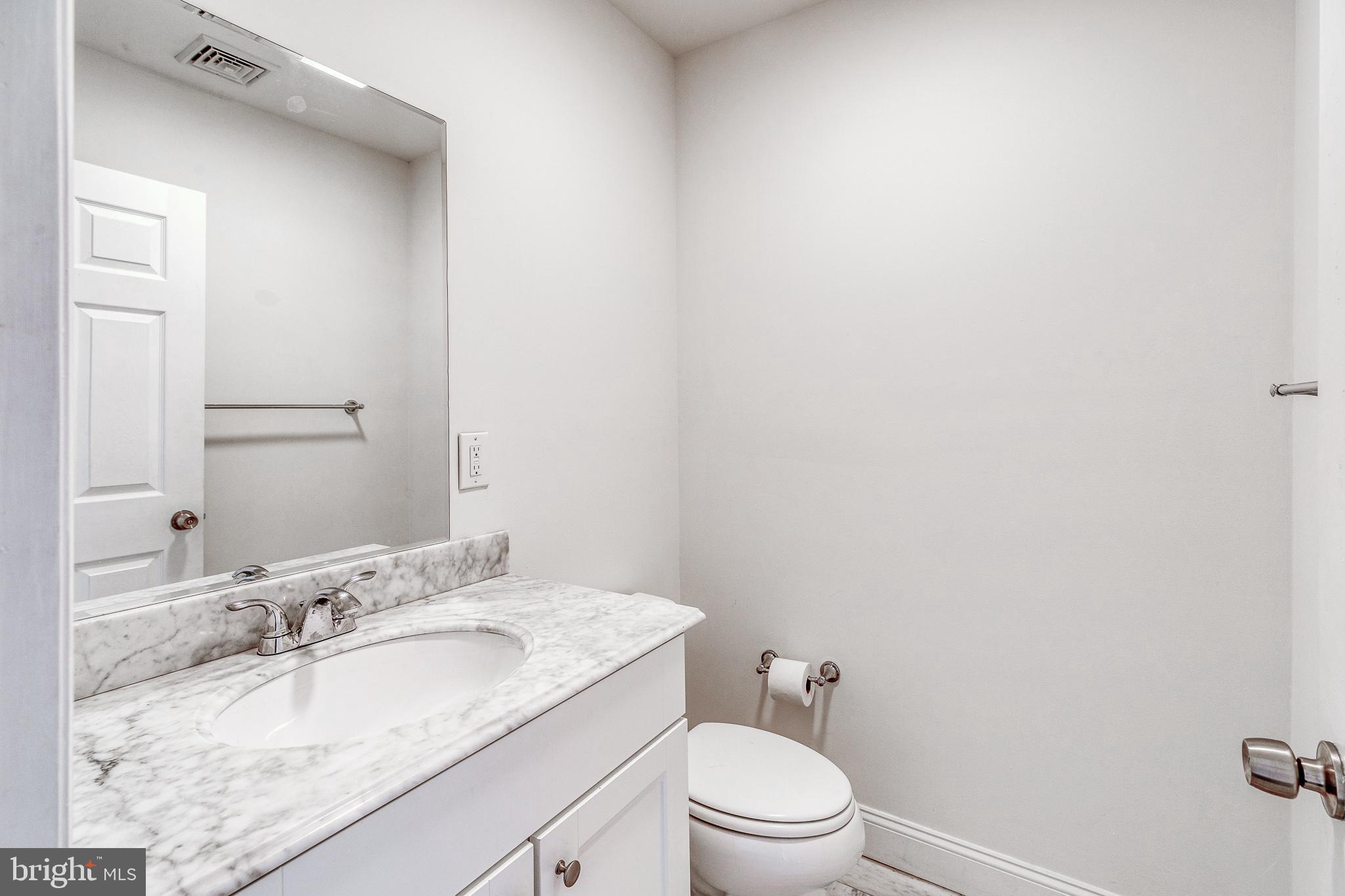 1714 Rittenhouse Square Philadelphia, PA 19103 - Photo 18 of 21 a bathroom with a granite countertop sink a toilet and mirror