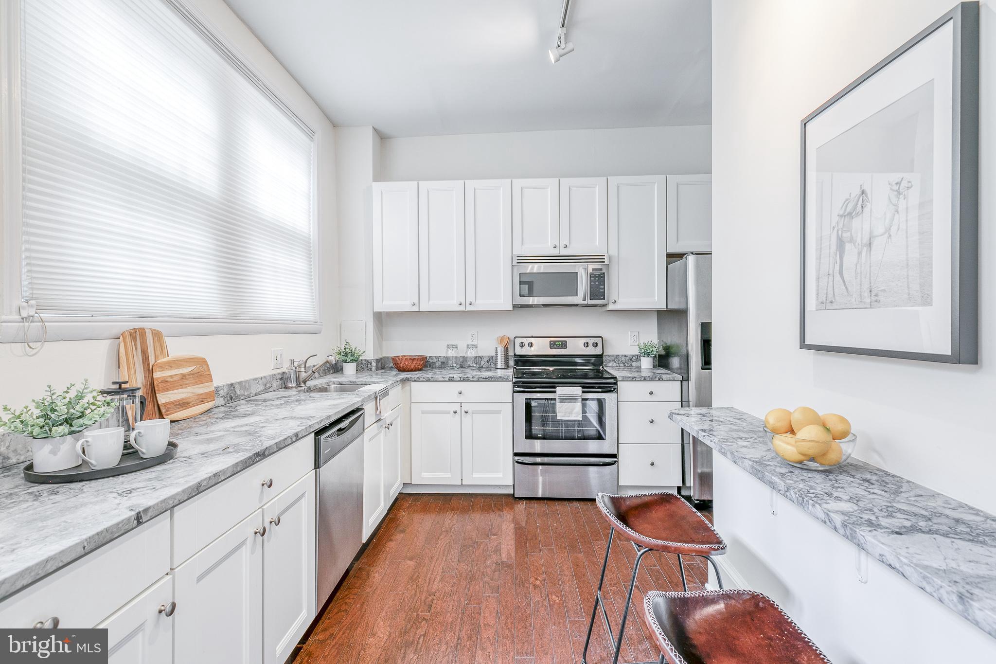 1714 Rittenhouse Square Philadelphia, PA 19103 - Photo 6 of 21 a kitchen with stainless steel appliances granite countertop a stove refrigerator sink and cabinets