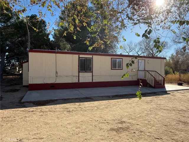 a view of house with backyard and trees