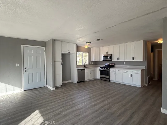 a large kitchen with cabinets wooden floor and stainless steel appliances