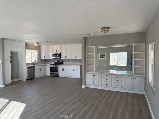 a kitchen with granite countertop a stove a sink dishwasher and a refrigerator
