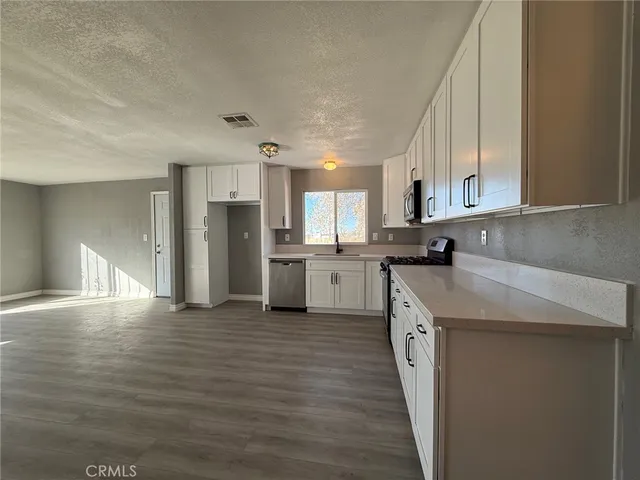 a kitchen with stainless steel appliances granite countertop a sink and cabinets