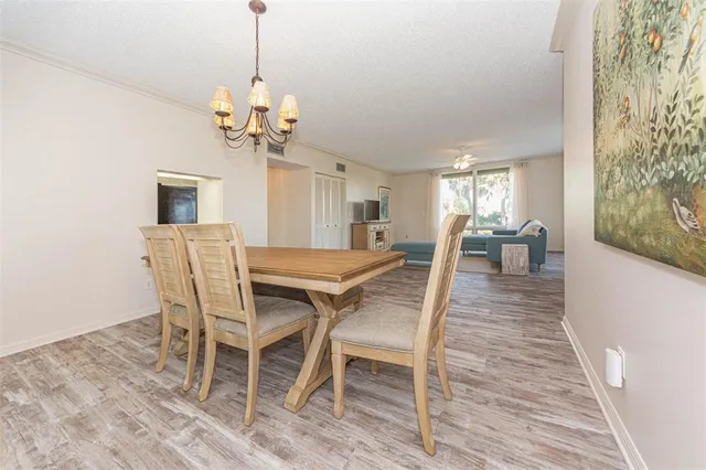 a dining room with furniture a chandelier and wooden floor