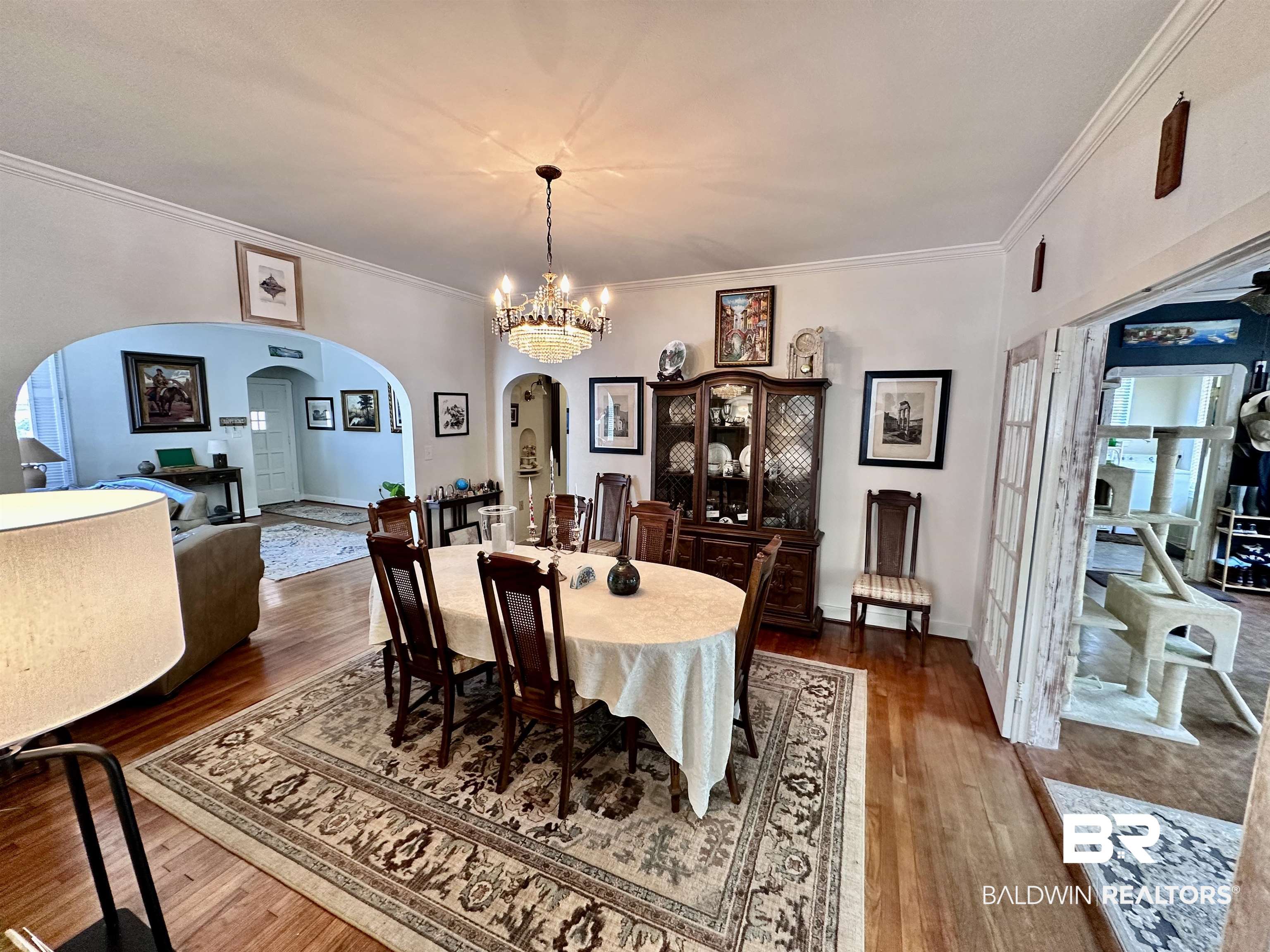 260 Siena Vista Street Mobile, AL 36607 - Photo 6 of 41 Dining area featuring arched walkways, dark wood-style flooring, ornamental molding, a chandelier, and baseboards