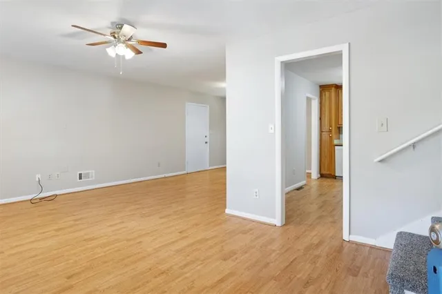 a view of a big room with wooden floor and a chandelier fan