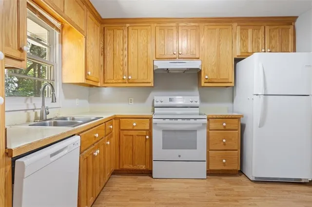 a kitchen with a refrigerator sink and cabinets