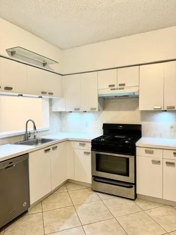 a kitchen with a stove a refrigerator and cabinets