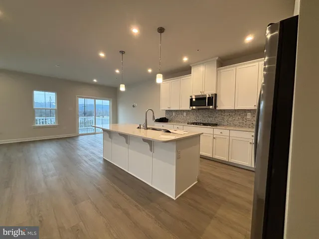 a kitchen with a refrigerator and a stove top oven