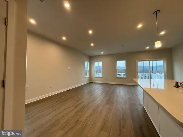 a view of a room with wooden floor and windows