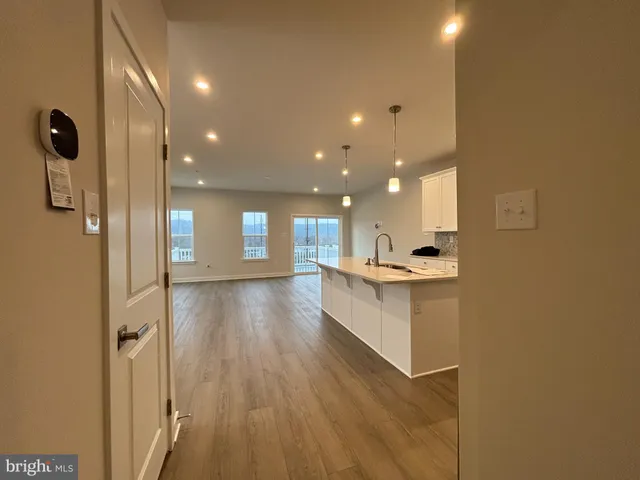 a open hall with cabinets and wooden floor