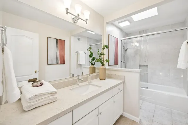 a bathroom with a double vanity sink mirror and shower
