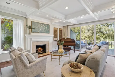 a living room with furniture a large window and a fireplace
