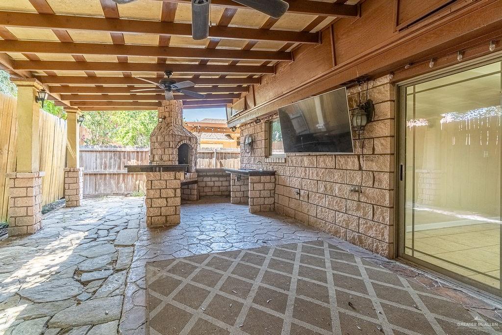 919 Hill Country Road Edinburg, TX 78539 - Photo 15 of 22 Covered patio featuring flagstone flooring, a built-in outdoor kitchen with a stone-clad pizza oven, and a ceiling fan
