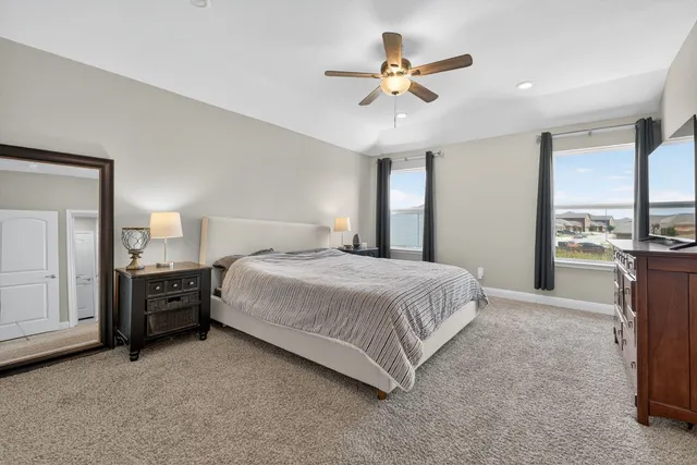 a spacious bedroom with a bed and a chandelier