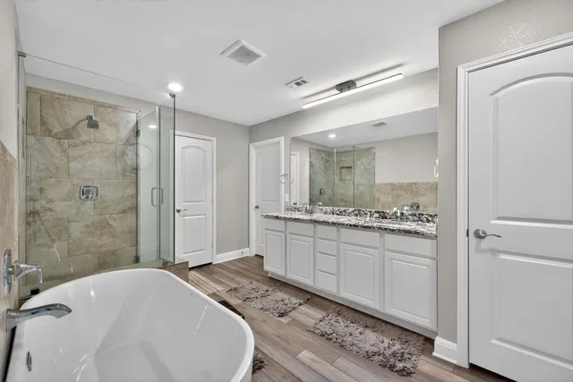 a bathroom with a granite countertop sink a toilet and shower