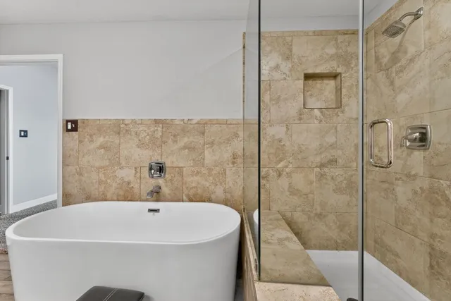 a bathroom with a white bath tub and a shower