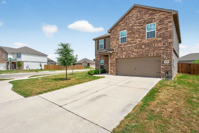a view of a brick house with a yard