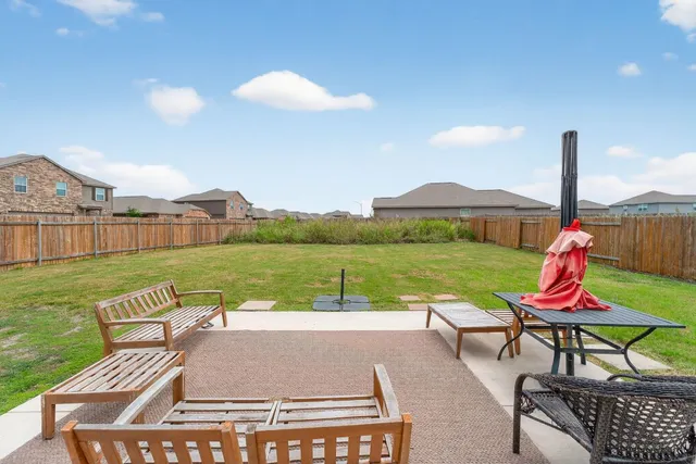 a view of a wooden chairs and table in patio with a lake view