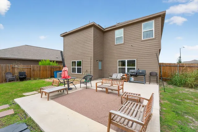 a backyard of a house with table and chairs