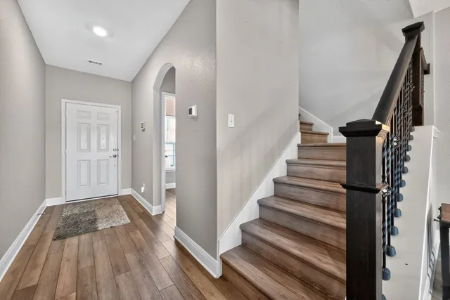 a view of a hallway with wooden floor and entryway